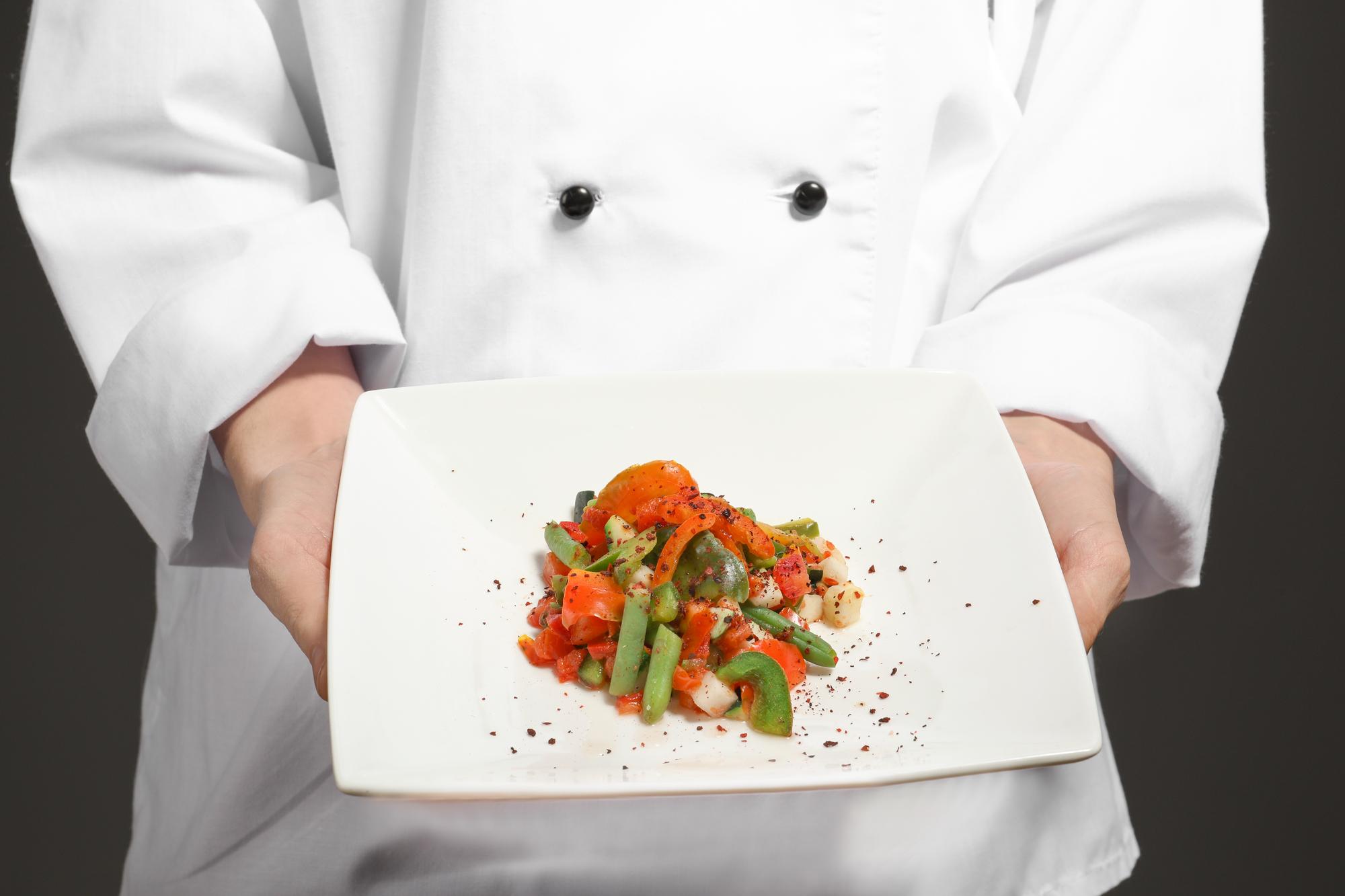 Chef che mostra un piatto pronto durante una lezione online